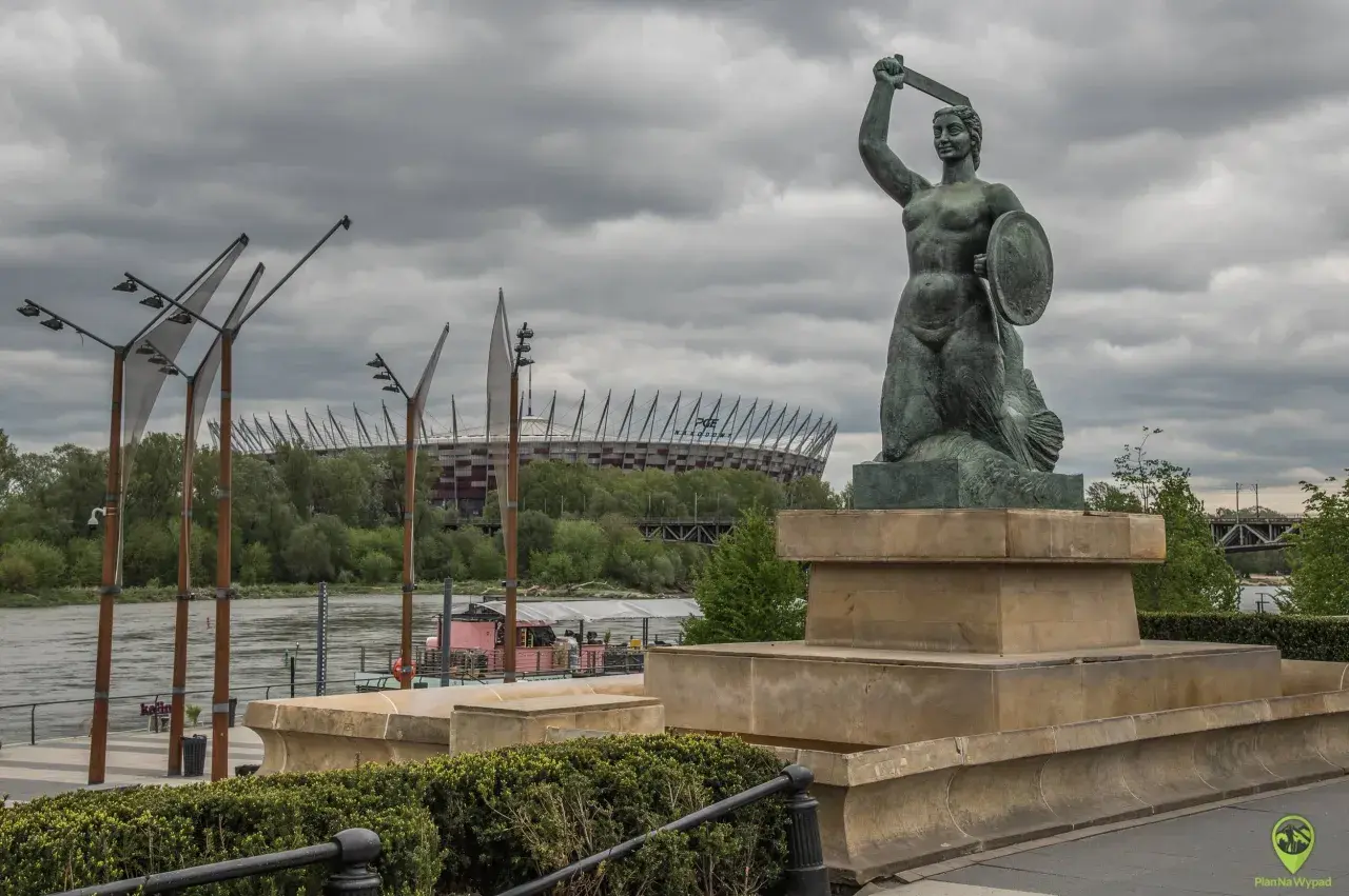 Syrenka Warszawska z tarczą i mieczem, w tle PGE Narodowy.
