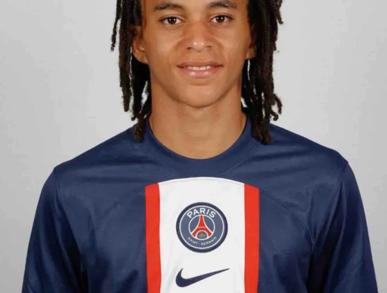Młody piłkarz Ethan Mbappé w koszulce PSG. Jego wiek to 16 lat.