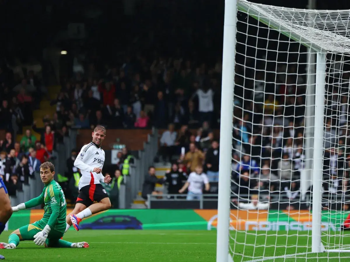 Emile Smith Rowe radośnie świętuje bramkę, podczas gdy bramkarz leży na murawie.