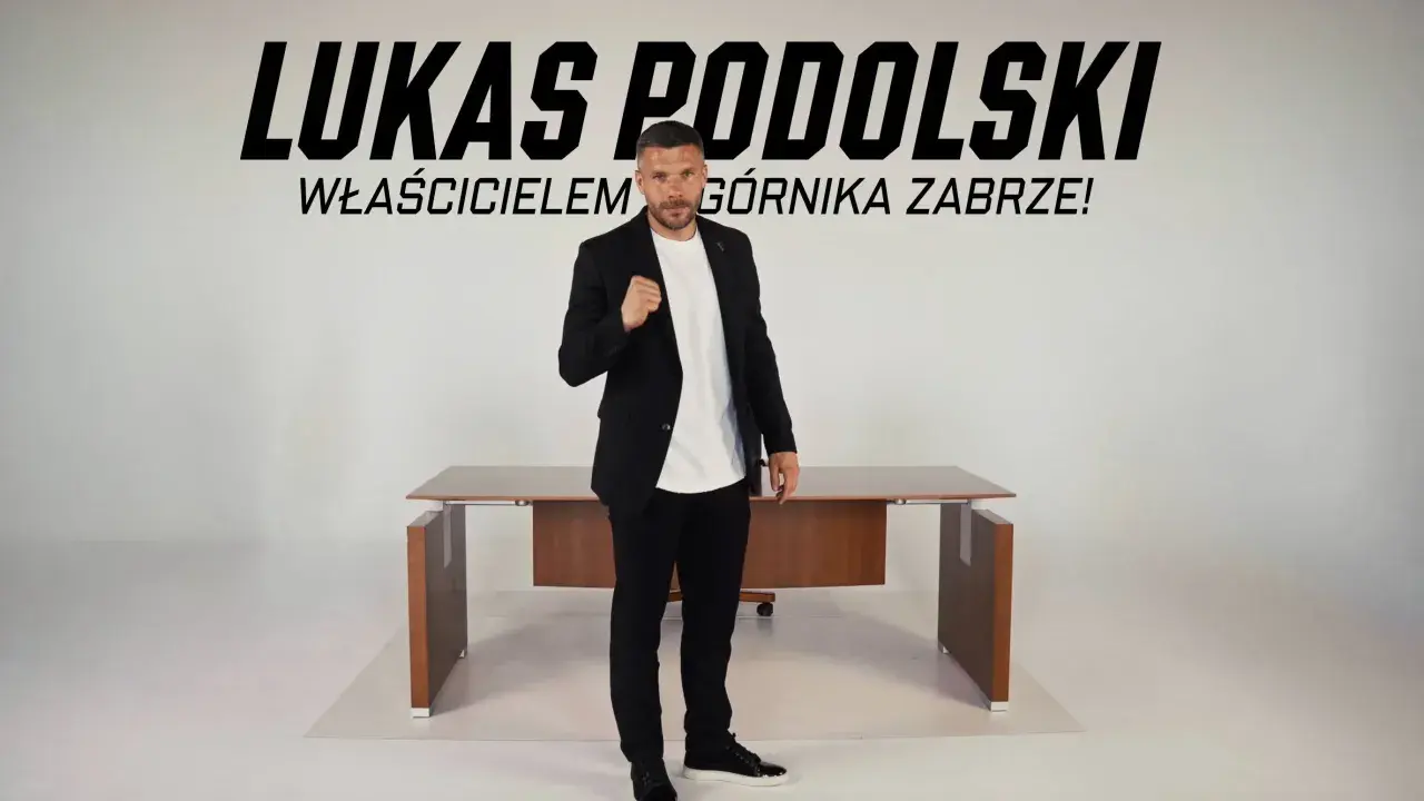 Łukasz Podolski, właściciel Górnika Zabrze, w garniturze przed biurkiem. Najnowsze wiadomości z klubu.