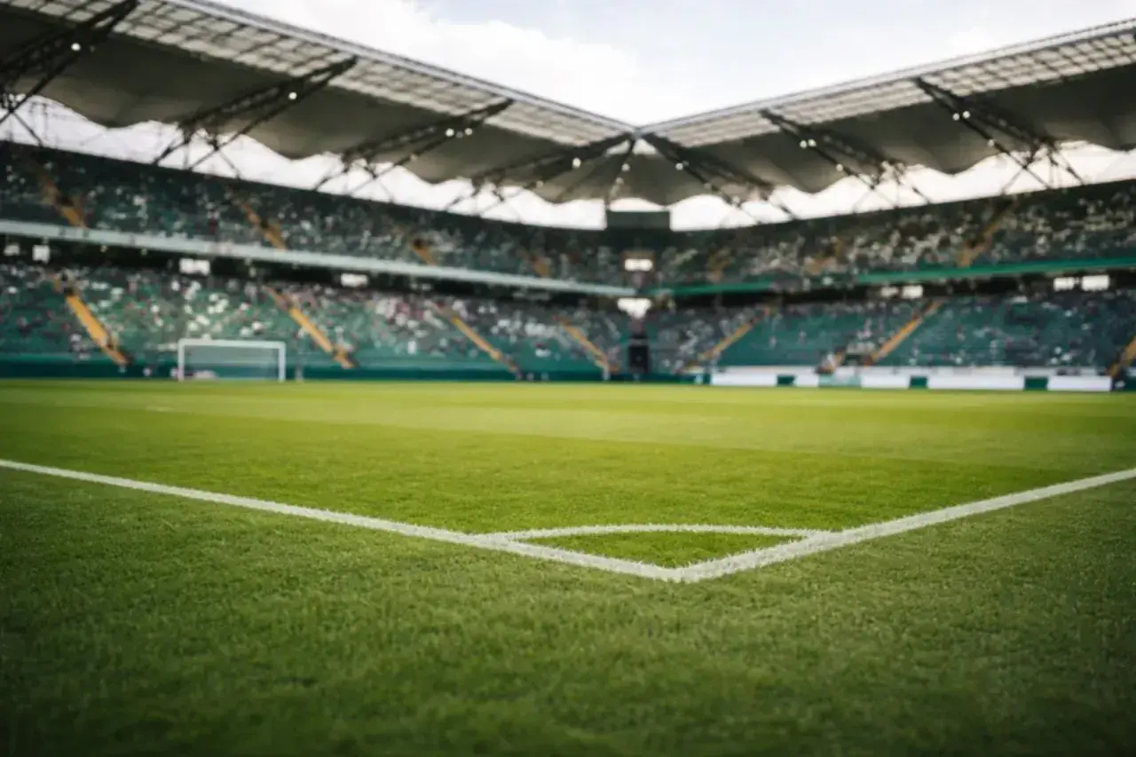 Piłkarskie boisko z trybunami wypełnionymi kibicami. Widok z narożnika boiska, gotowego na emocje w baraze 1 liga.
