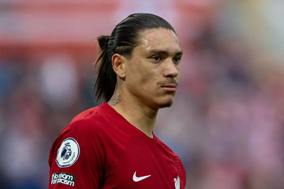Darwin Nunez w czerwonej koszulce Liverpoolu, z charakterystycznym kucykiem i tatuażem na szyi, gotowy do gry.