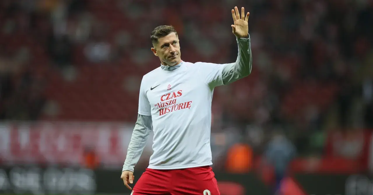 Zbigniew Robert Lewandowski w koszulce z napisem "Czas na naszą historię" pozdrawia kibiców.