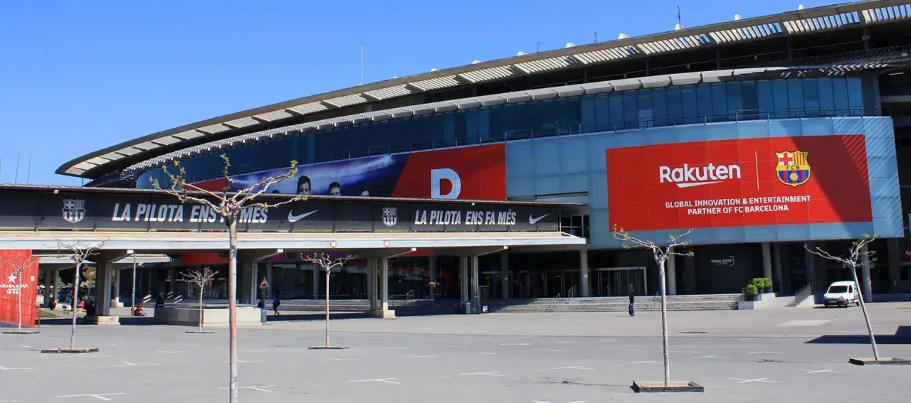 Stadion, gdzie gra Barcelona, z banerem Rakuten i herbem FCB.