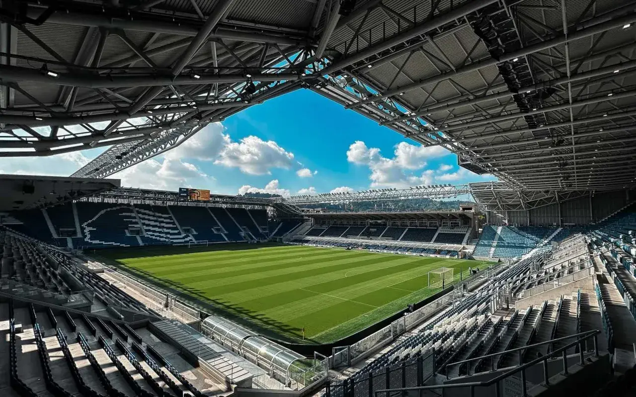 Puste trybuny stadio Atleti Azzurri d'Italia czekają na kibiców. Zielona murawa lśni w słońcu, gotowa na emocje.