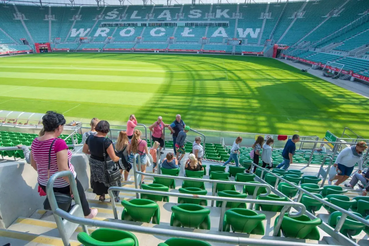 Grupa turystów zwiedza pusty stadion Śląsk Wrocław.
