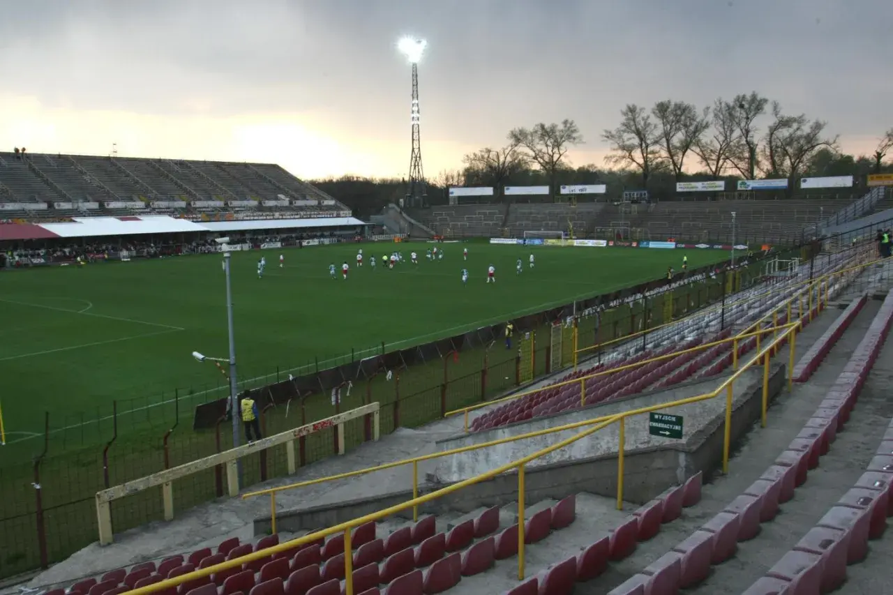 Stary stadion ŁKS, z murawą i trybunami, gdzie trwa mecz.