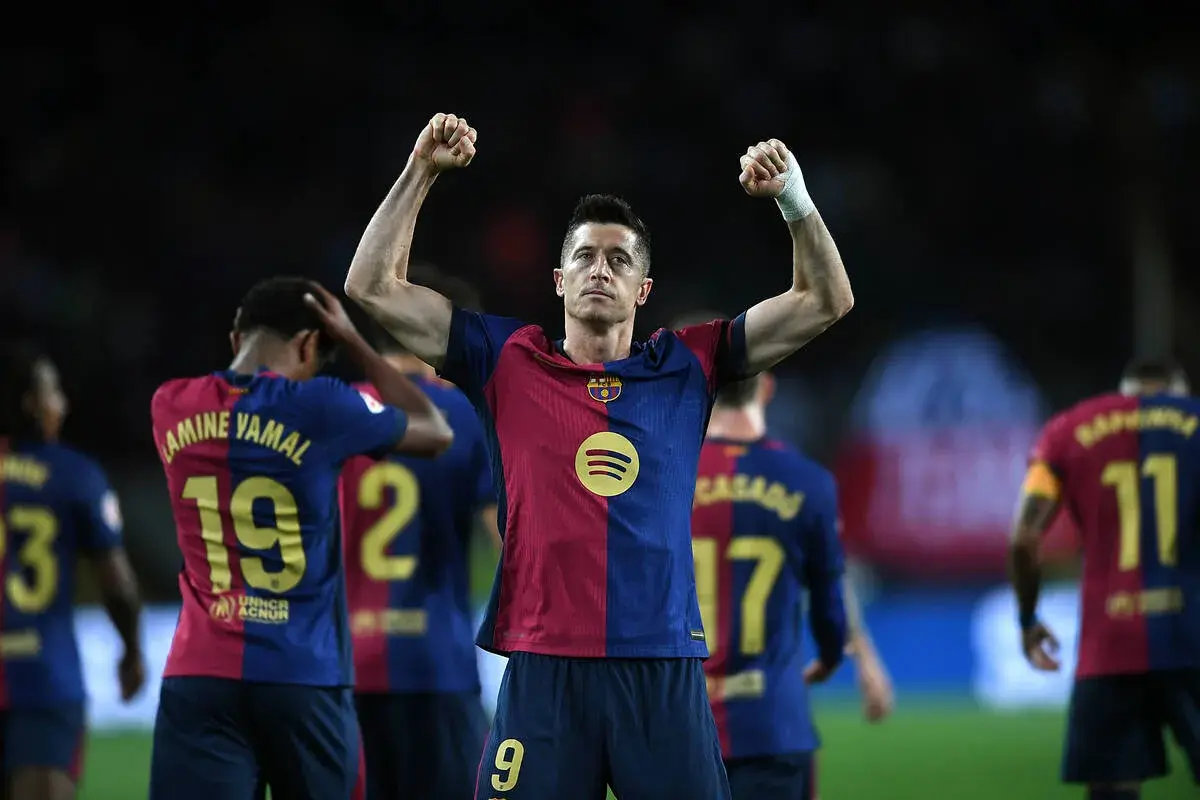Robert Lewandowski świętuje kolejne bramki, podnosząc ręce w geście triumfu.