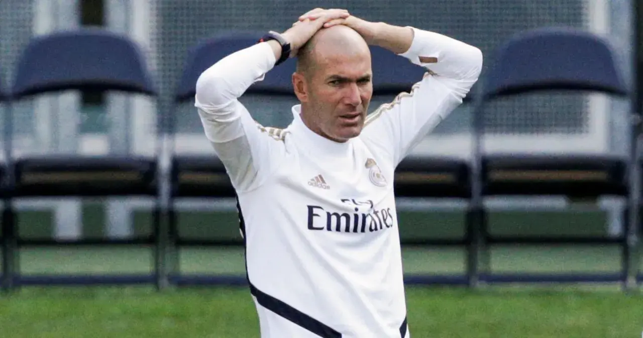 Zinedine Zidane, trener Real Madryt 2017, z rękami na głowie, w białej koszulce treningowej.