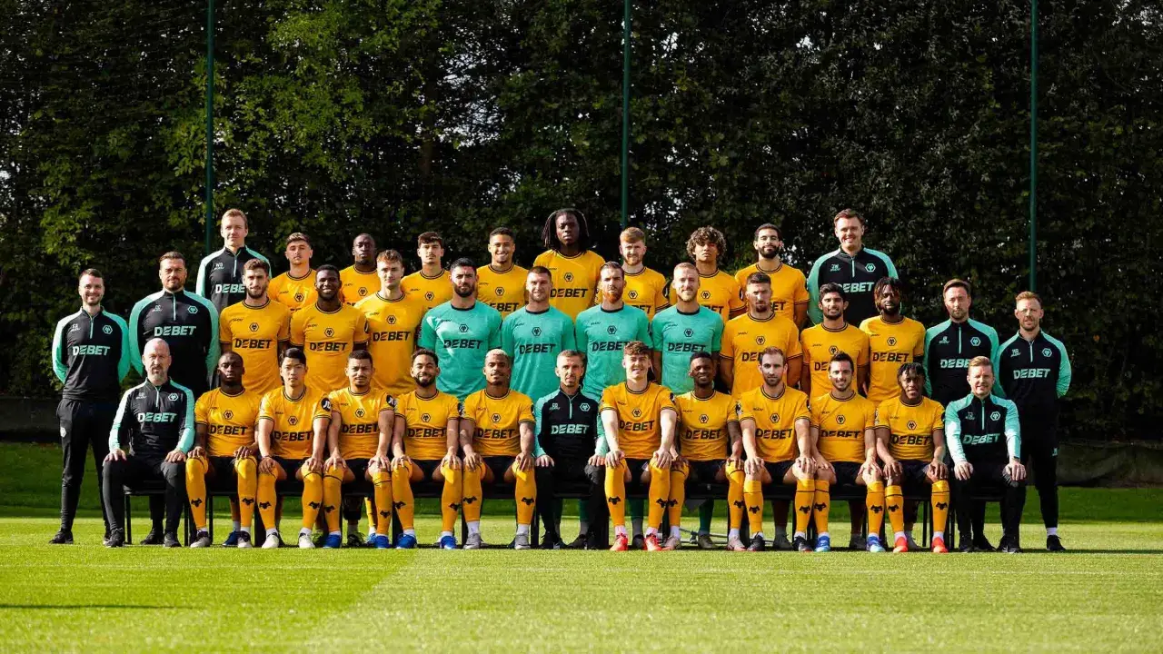 Wolverhampton Wanderers F.C. – zawodnicy w żółtych i zielonych strojach pozują do zdjęcia drużynowego na boisku.