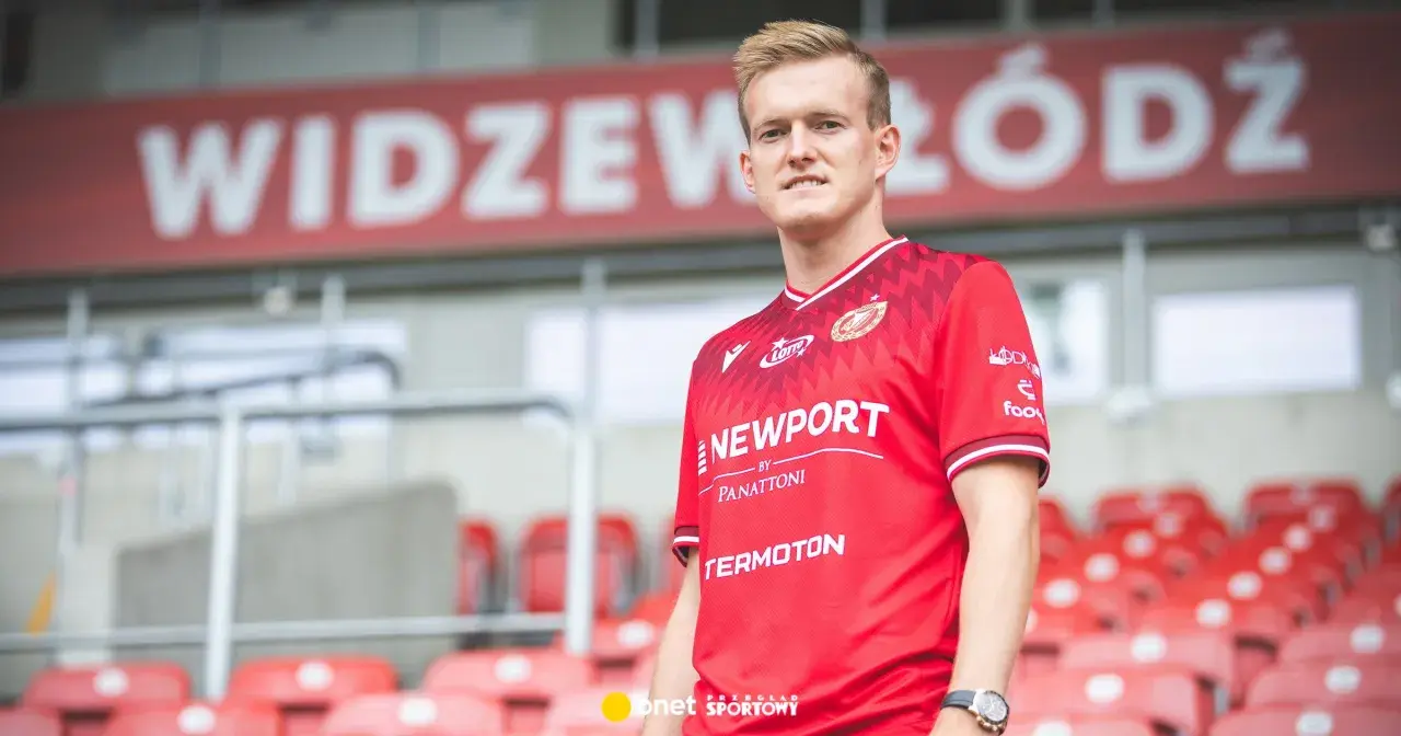 Piłkarz Karol Świderski w czerwonej koszulce Widzewa Łódź. Jego zarobki budzą zainteresowanie kibiców.