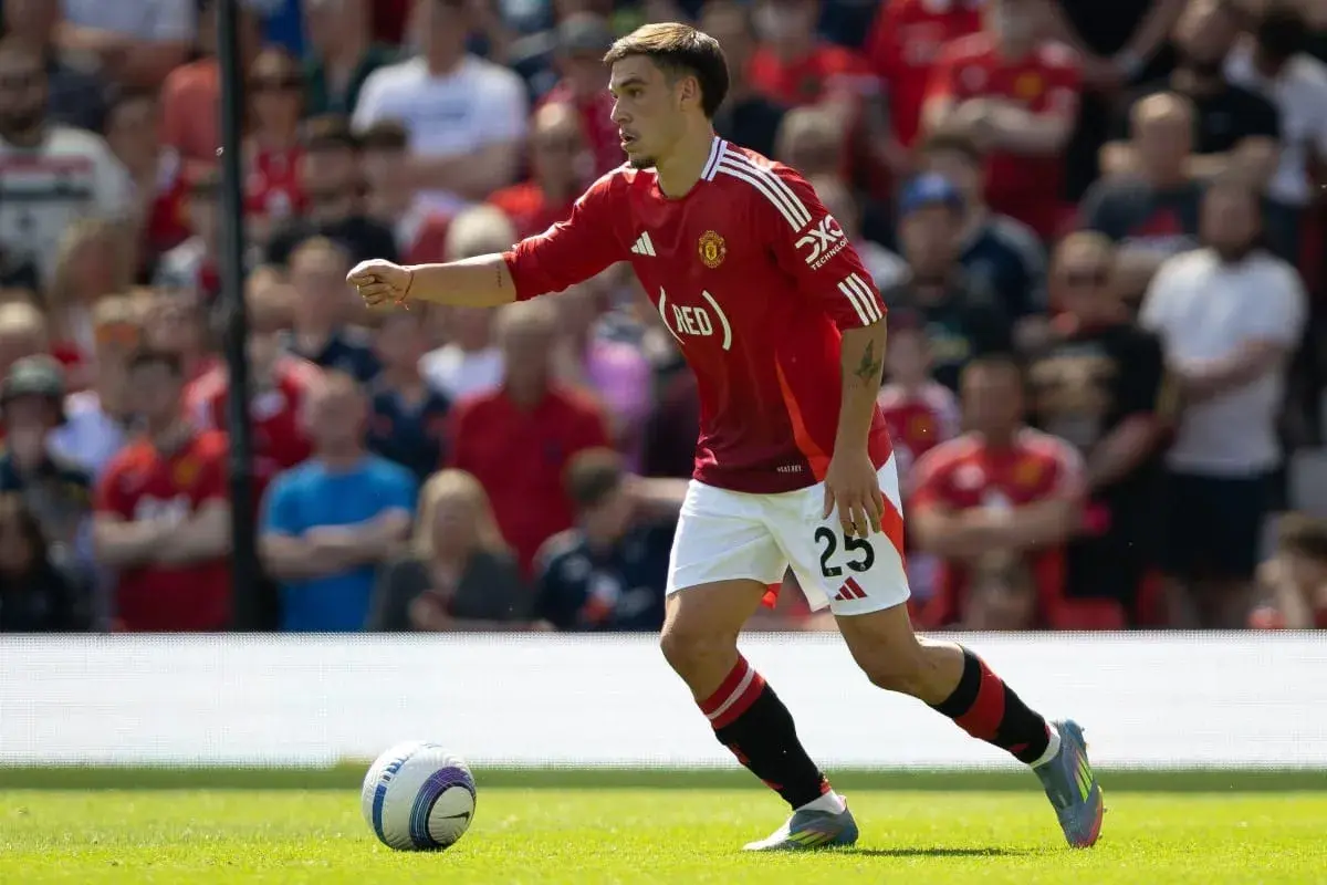 Manuel Ugarte w czerwonej koszulce Manchesteru United z numerem 25, biegnie po boisku, skupiony na grze.