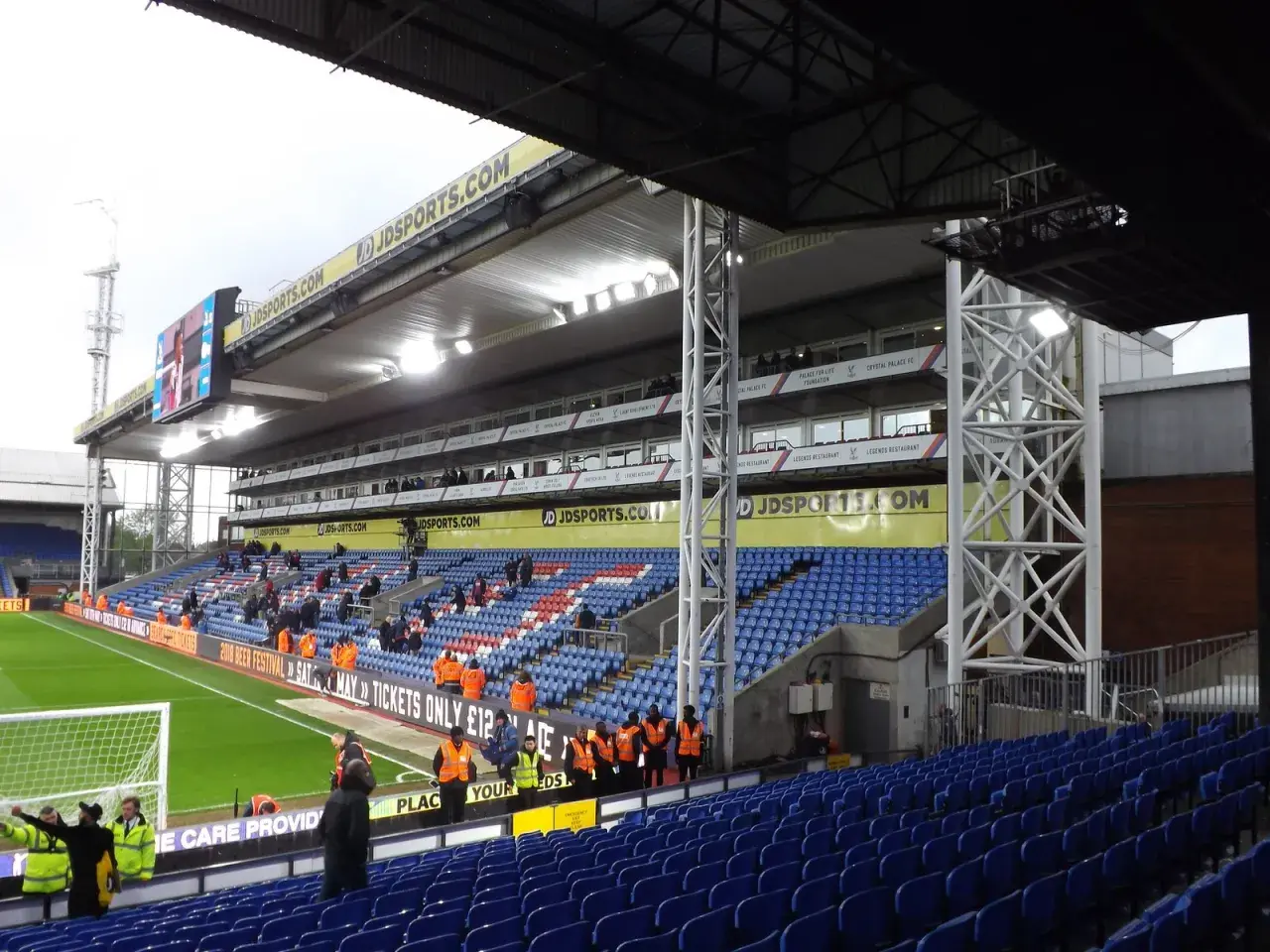 Puste trybuny stadionu Crystal Palace, z widokiem na murawę i tablicę wyników.