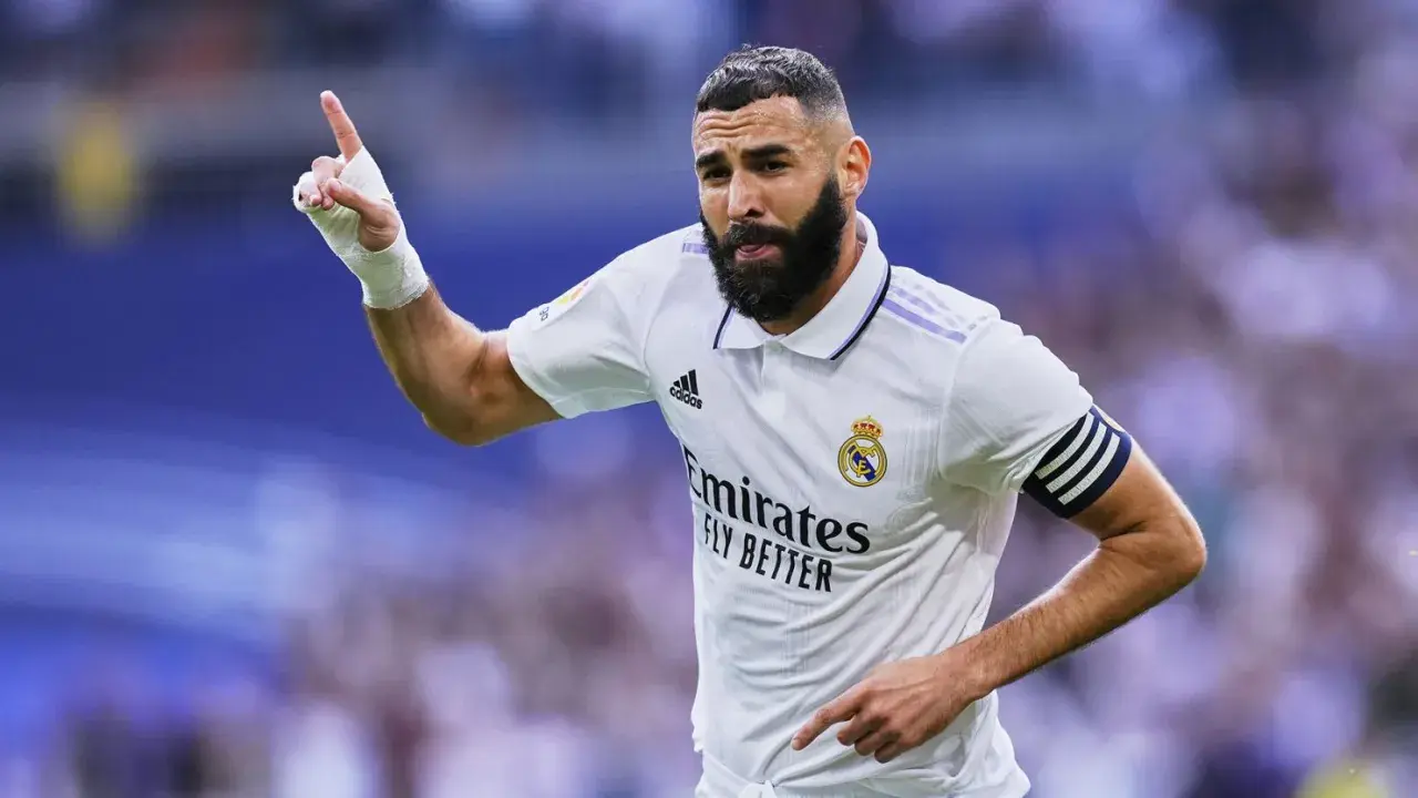 Piłkarz z numerem 8, Karim Benzema, świętuje bramkę. Ma zabandażowaną dłoń i opaskę kapitana na ramieniu.