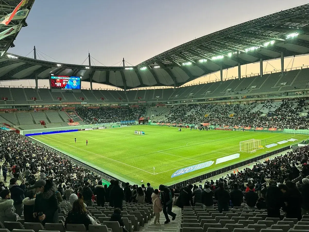 Widok na wypełniony po brzegi seulski stadion piłkarski, gdzie kibice czekają na rozpoczęcie meczu.