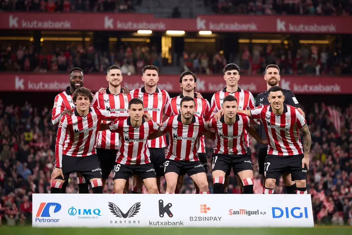 Athletic Bilbao – zawodnicy w czerwono-białych pasach stoją razem przed kibicami.