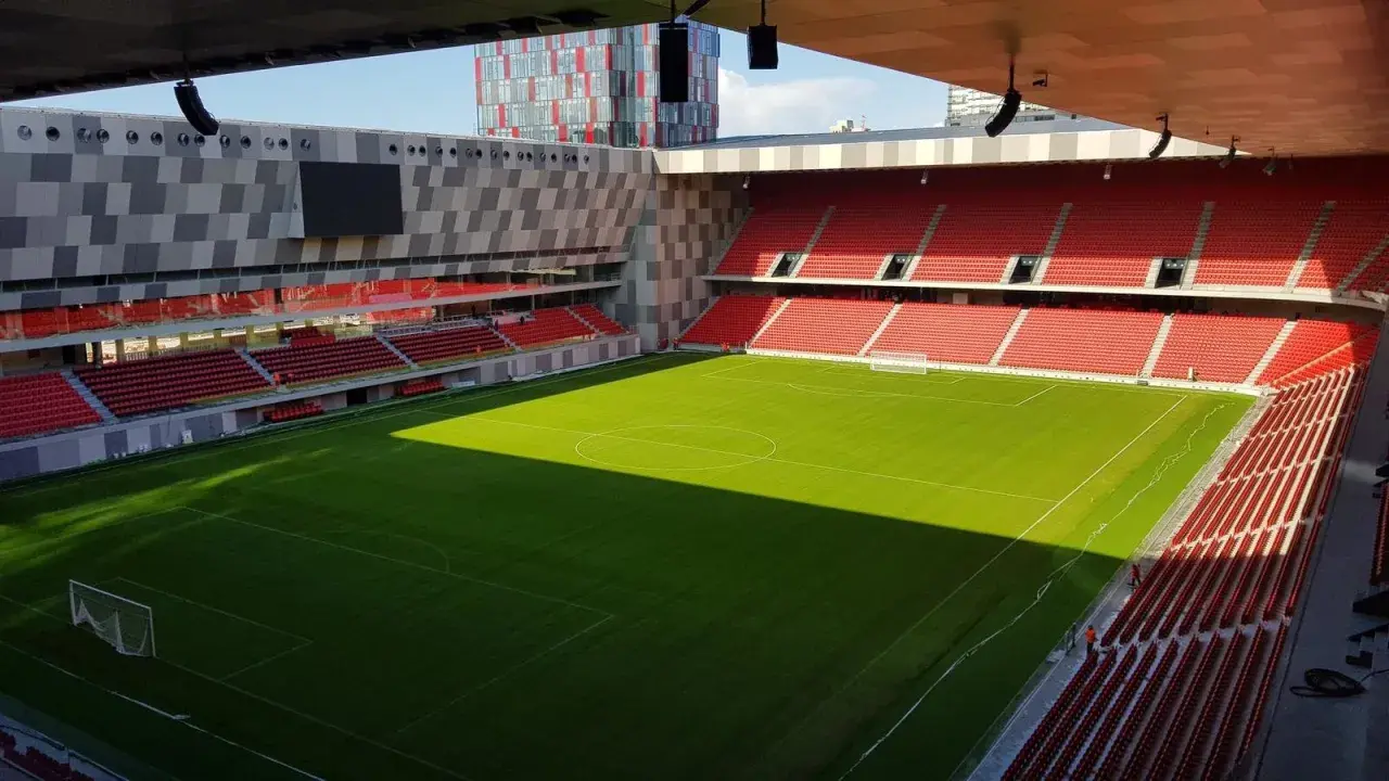 Piękny, zielony stadion w Tiranie, stolicy Albanii. Puste czerwone trybuny czekają na kibiców.