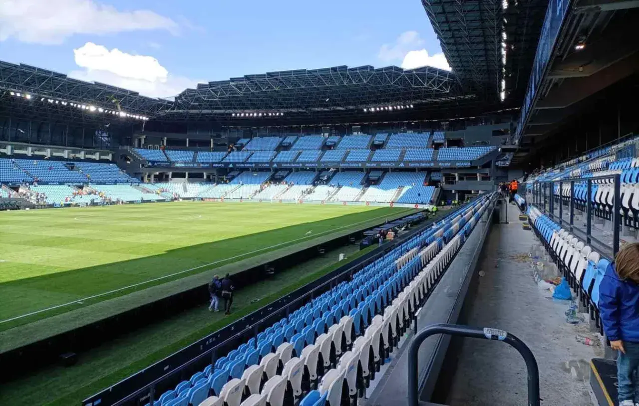 Puste trybuny stadionu Celta Vigo czekają na kibiców. Zielona murawa lśni w słońcu.