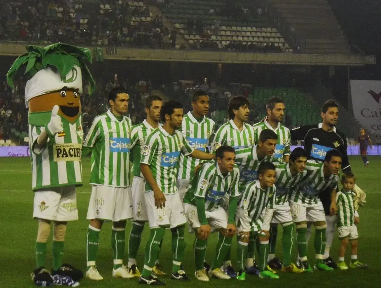 Real Betis – zawodnicy w zielono-białych strojach pozują do zdjęcia z maskotką.