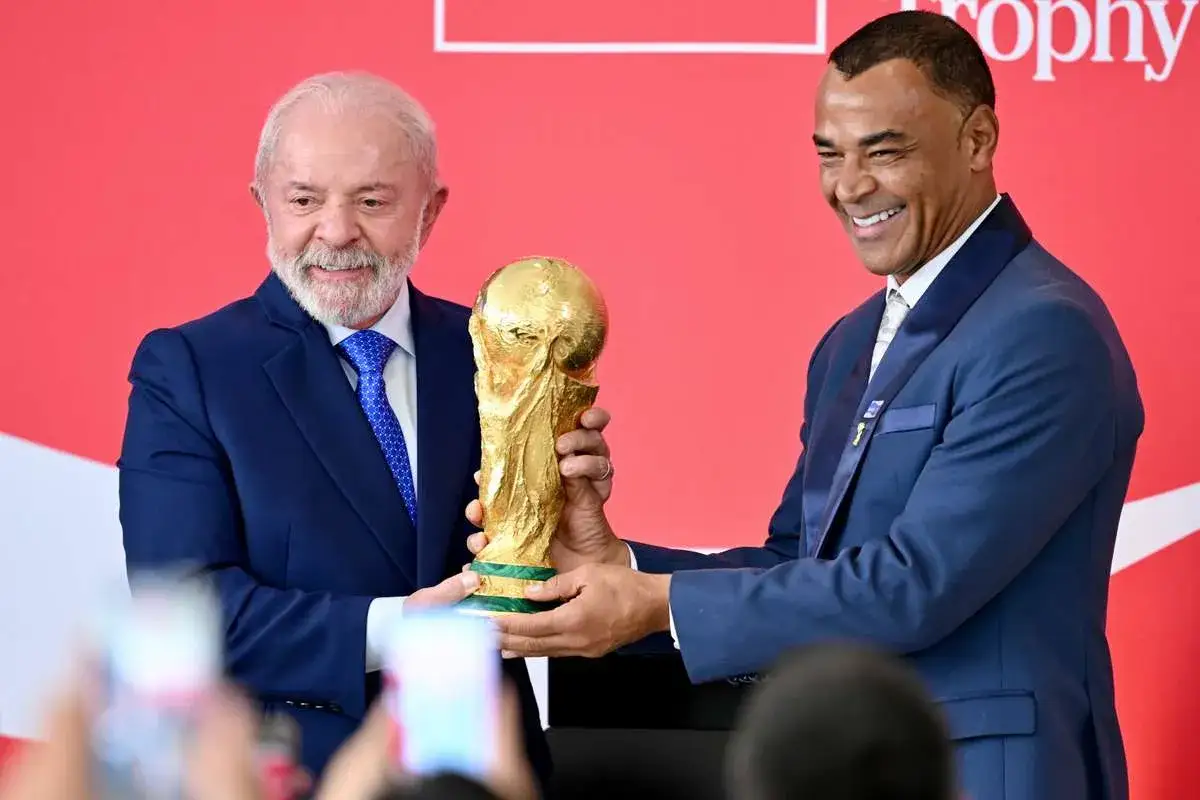 Prezydent Lula i Cafu trzymają Puchar Świata, symbol tego, ile razy Brazylia wygrała mistrzostwa świata.