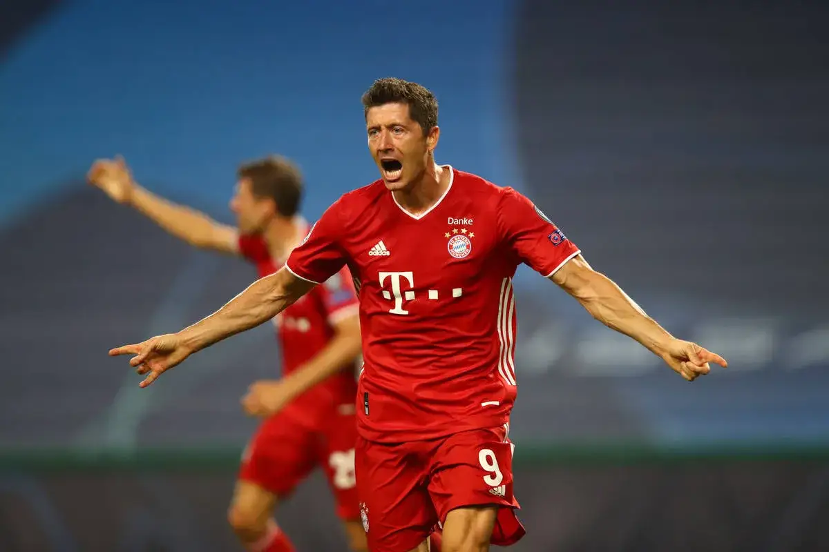 Robert Lewandowski w czerwonej koszulce Bayernu świętuje bramkę w meczu przeciwko Borussii Dortmund.