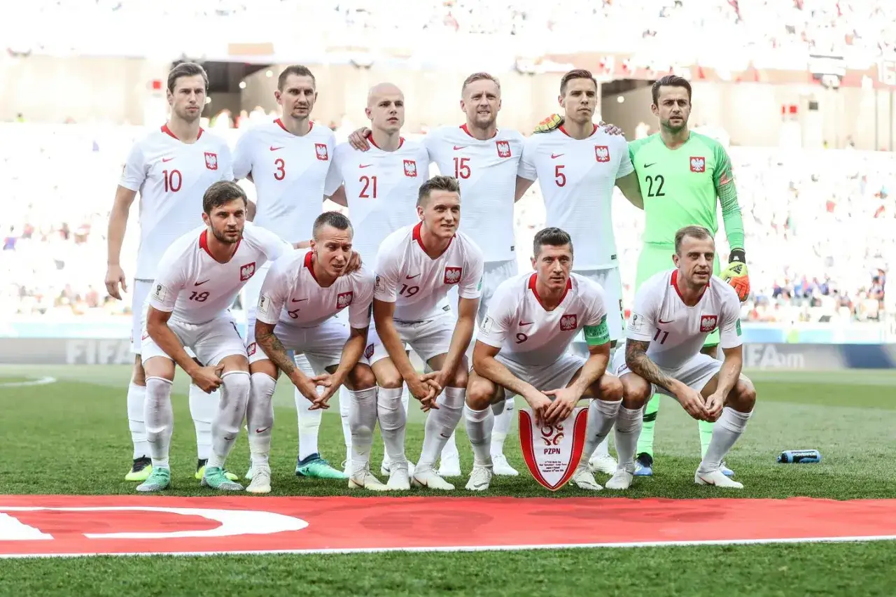 Reprezentacja Polski w piłce nożnej, gotowa do meczu. Białe koszulki z orłem, symbolizujące polską dumę, czekają na starcie z Japonią.