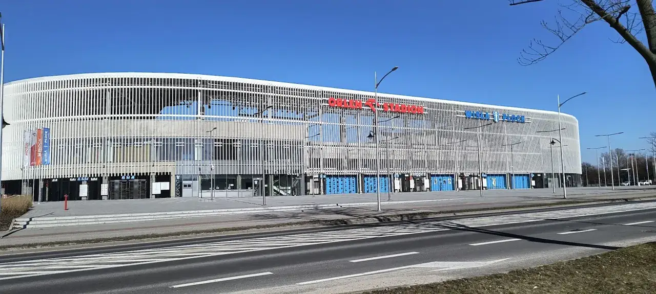 Nowoczesny stadion im. Kazimierza Górskiego w Płocku, z charakterystyczną białą fasadą i niebieskimi bramami.