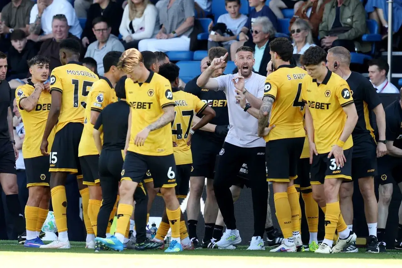 Trener Wolves instruuje zawodników Wolverhampton Wanderers F.C. w żółtych strojach.