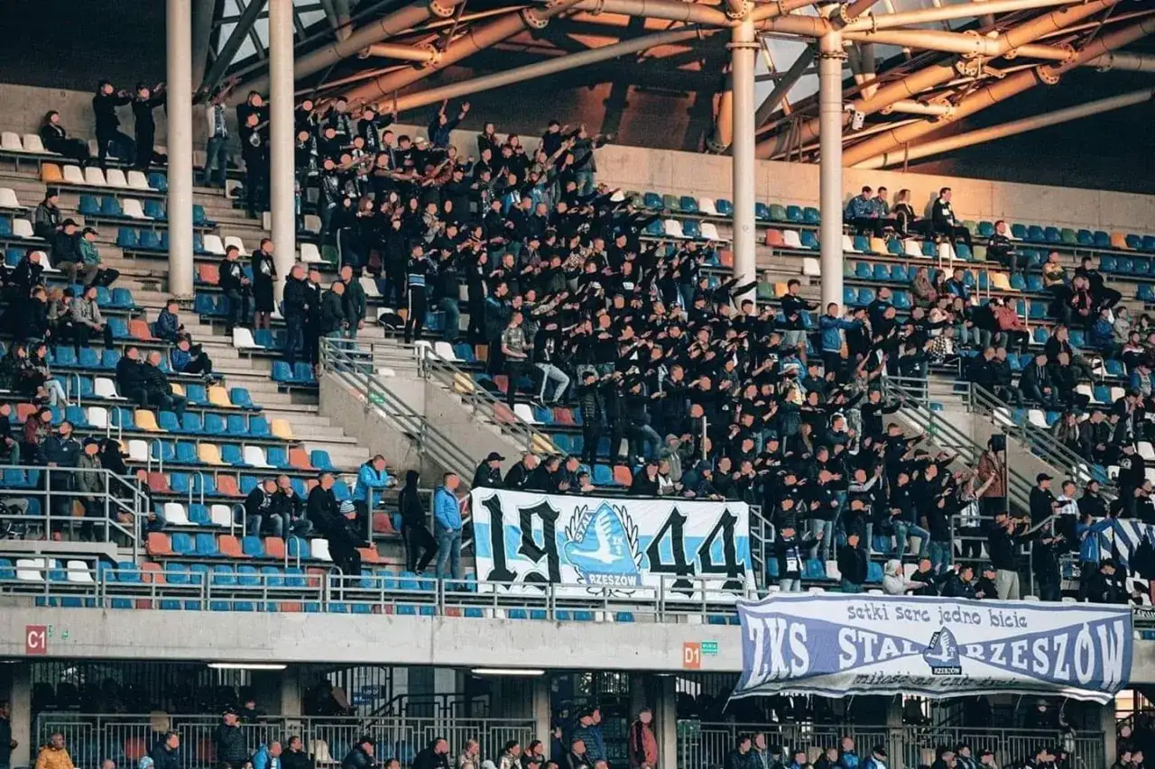 Tłum kibiców na trybunach stadionu, wspierający Stal Rzeszów. Widać transparenty z napisem
