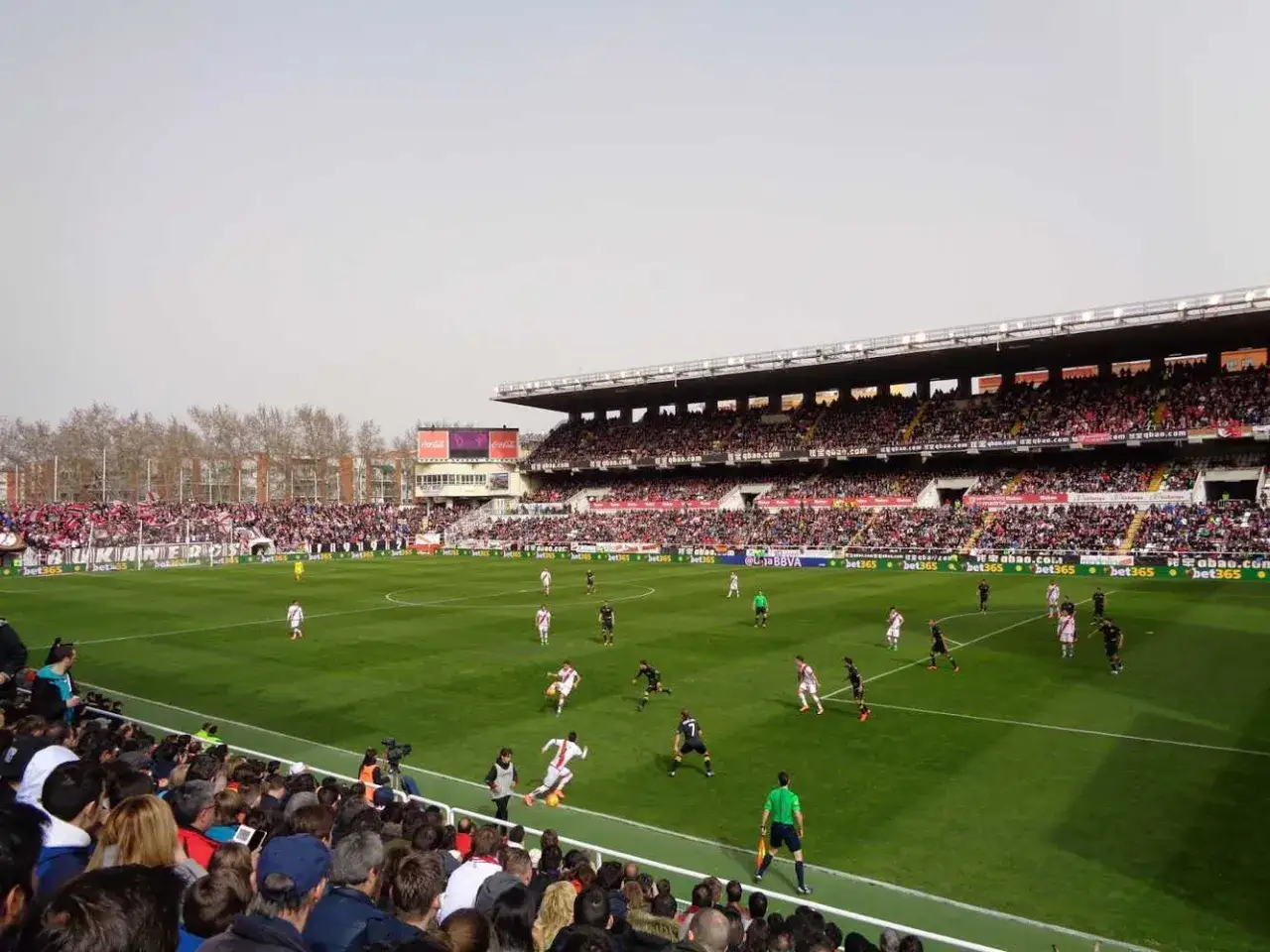 Mecz piłki nożnej Rayo Vallecano - Sevilla na stadionie, pełnym kibiców.