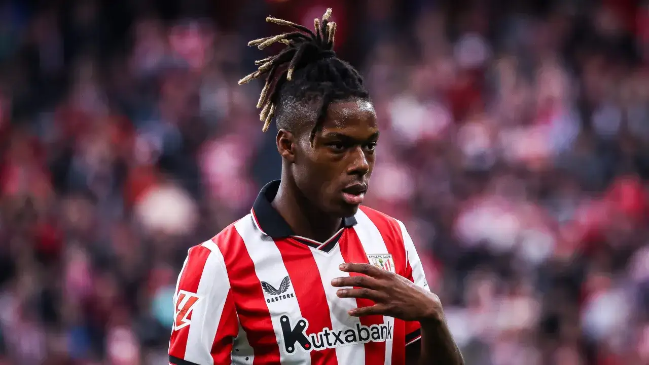 Athletic Bilbao – zawodnicy. Młody piłkarz z charakterystyczną fryzurą, w czerwono-białej koszulce, na tle trybun.