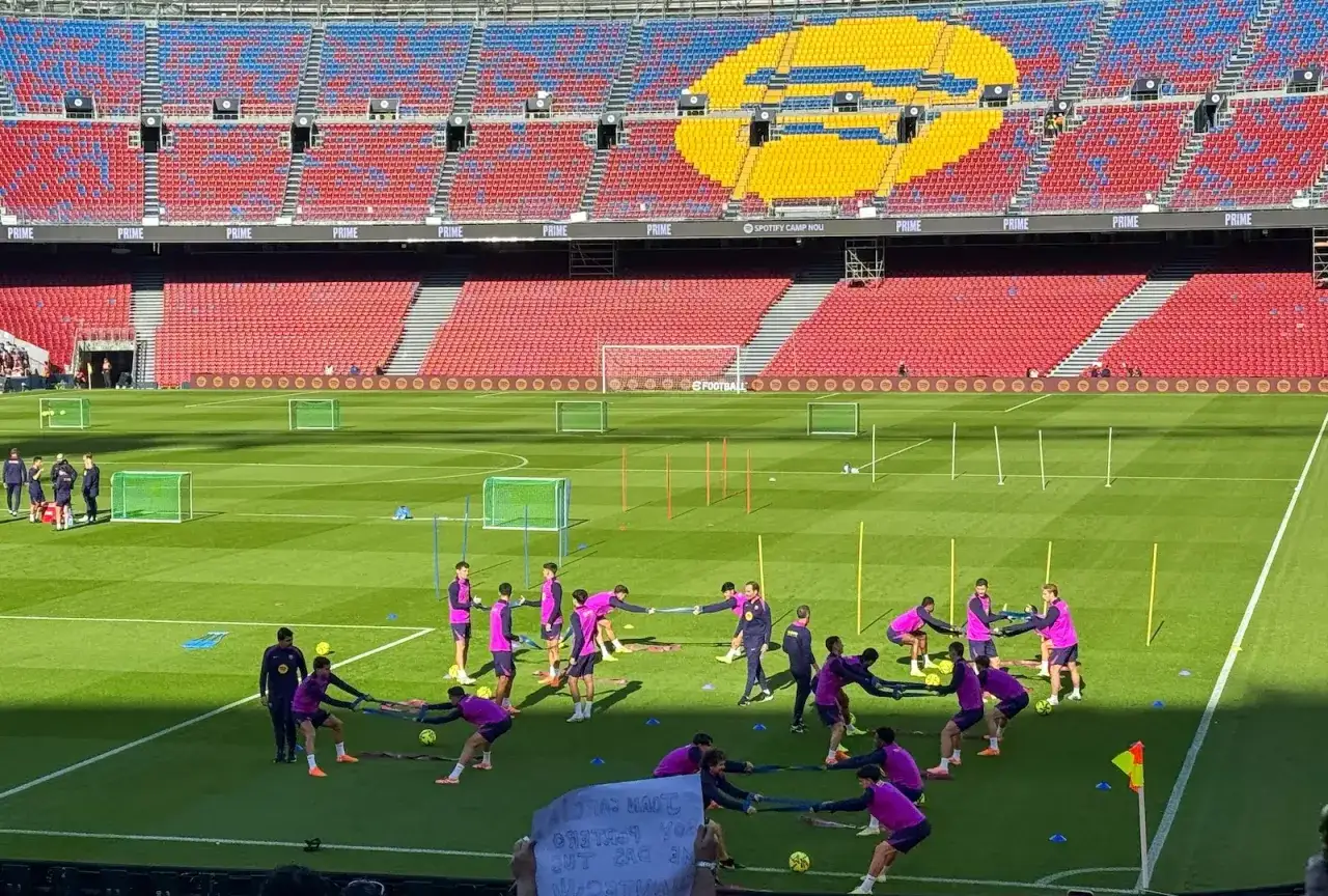 Piłkarze FC Barcelona B trenują na murawie stadionu Camp Nou, ćwicząc siłę z gumami oporowymi.