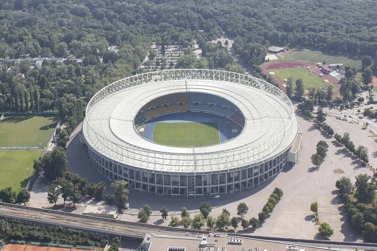Widok z lotu ptaka na Ernst Happel Stadion, otoczony zielenią, z boiskiem i bieżnią.