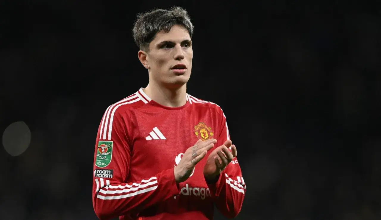 Alejandro Garnacho w czerwonej koszulce Manchesteru United, z dłońmi złożonymi w geście aplauzu, patrzy w bok.
