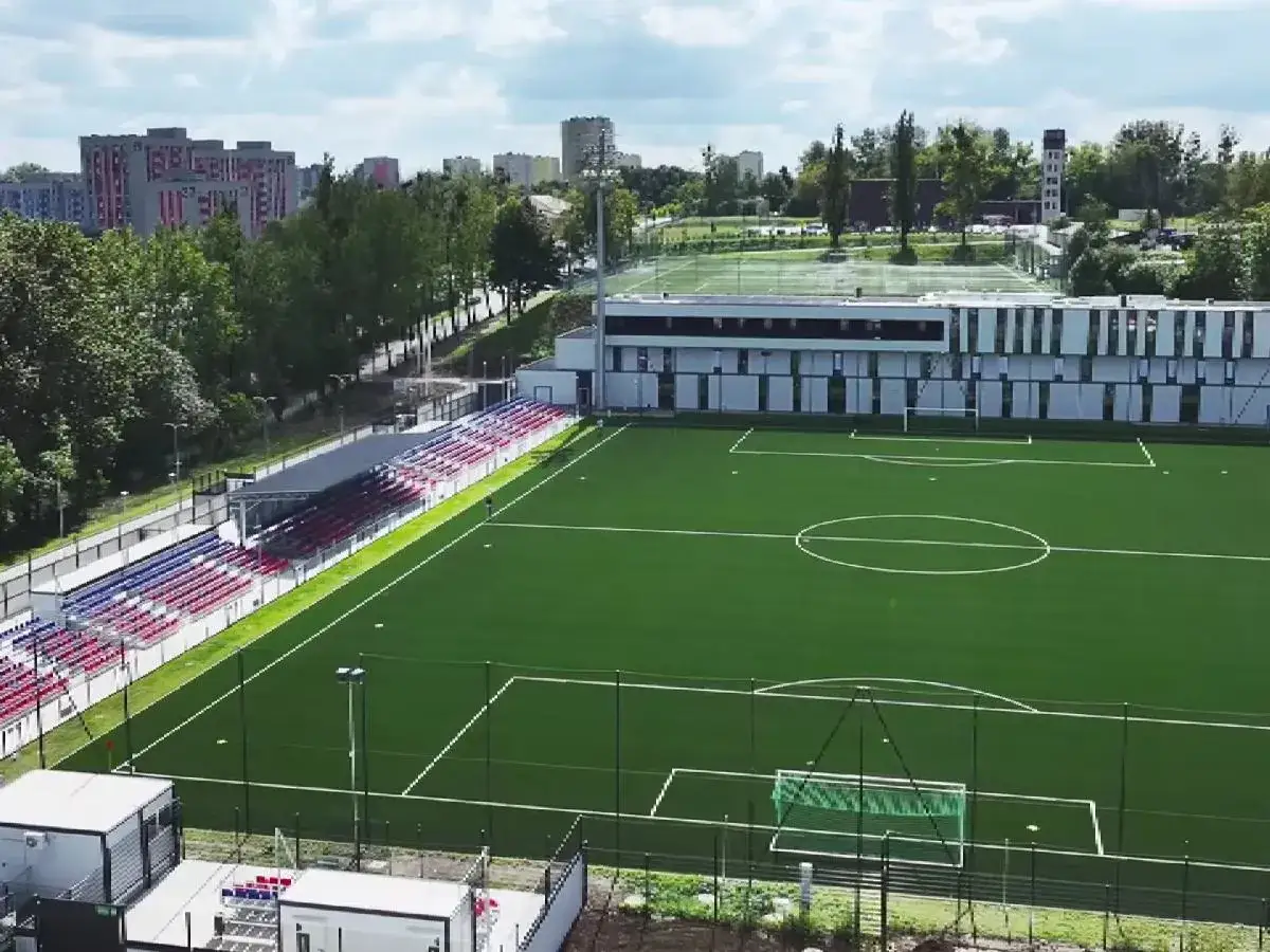 Nowoczesny stadion Polonii Bytom z zieloną murawą, trybunami i budynkiem klubowym.