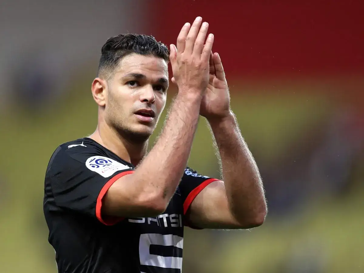 Piłkarz Hatem Ben Arfa klaszcze, ubrany w czarną koszulkę z czerwonymi wstawkami.