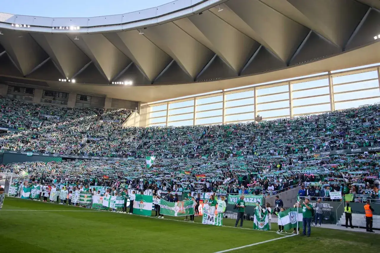 Tysiące kibiców w zielonych szalikach wypełnia trybuny stadionu Real Betis, tworząc zielone morze.