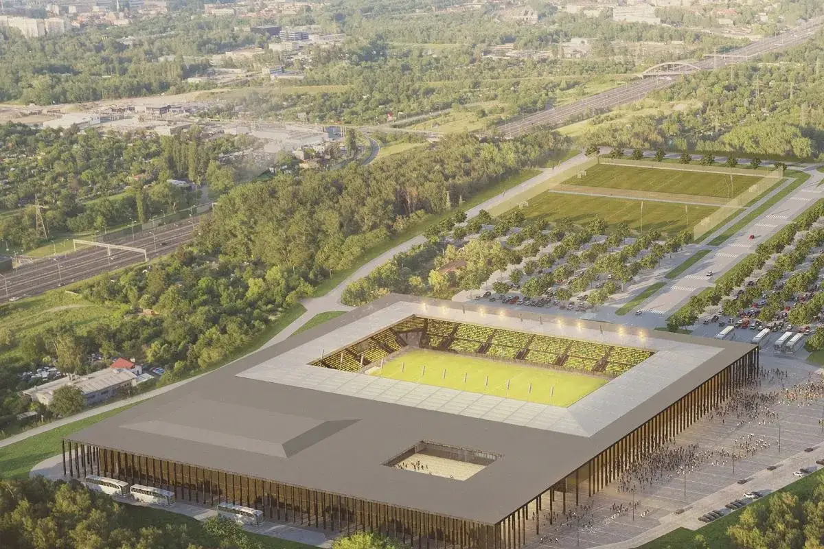 Nowoczesny stadion GKS Katowice z zieloną murawą i trybunami, otoczony parkingami i boiskami treningowymi.
