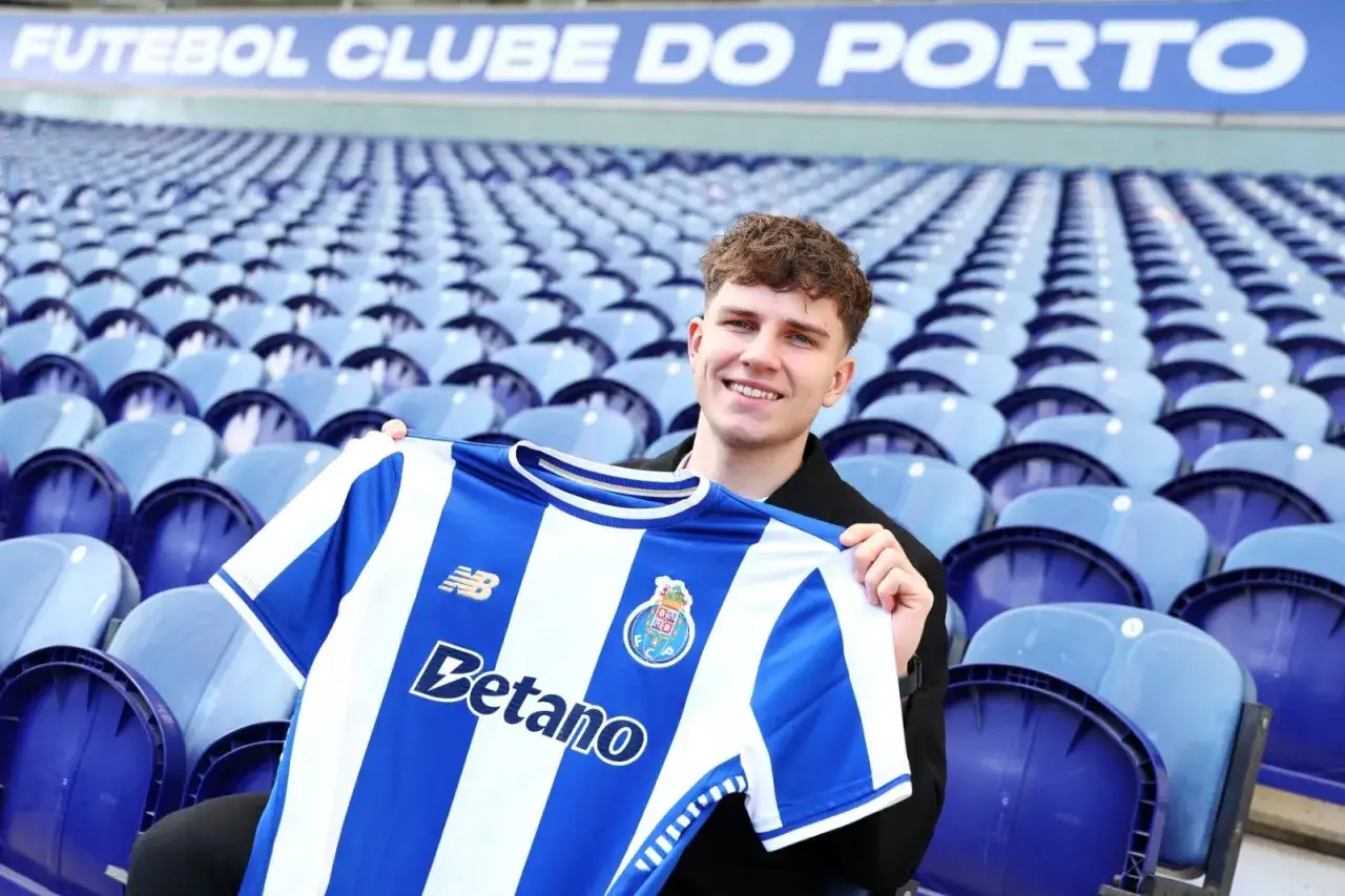 Oskar Pietuszewski z dumą prezentuje koszulkę FC Porto na tle pustych trybun stadionu.