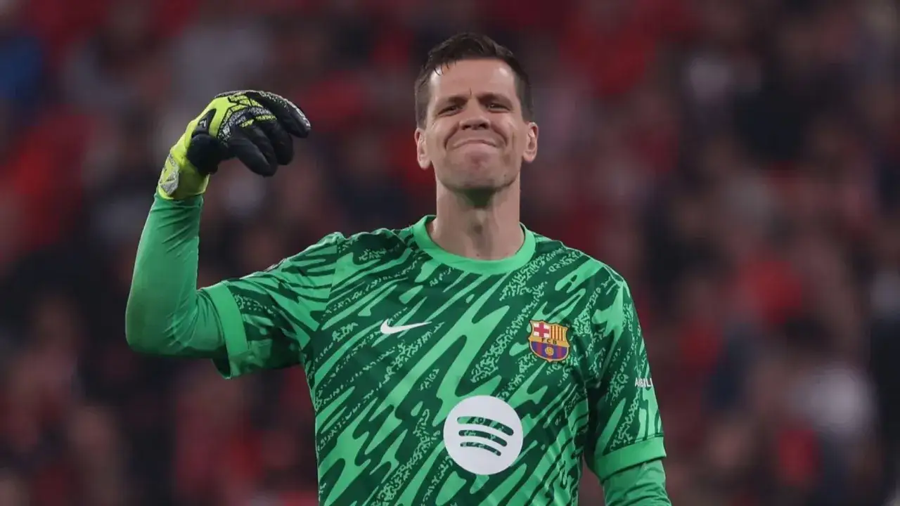 Wojciech Szczęsny w zielonej koszulce, z rękawicą w górze, cieszy się po udanych wojciech szczęsny gry.