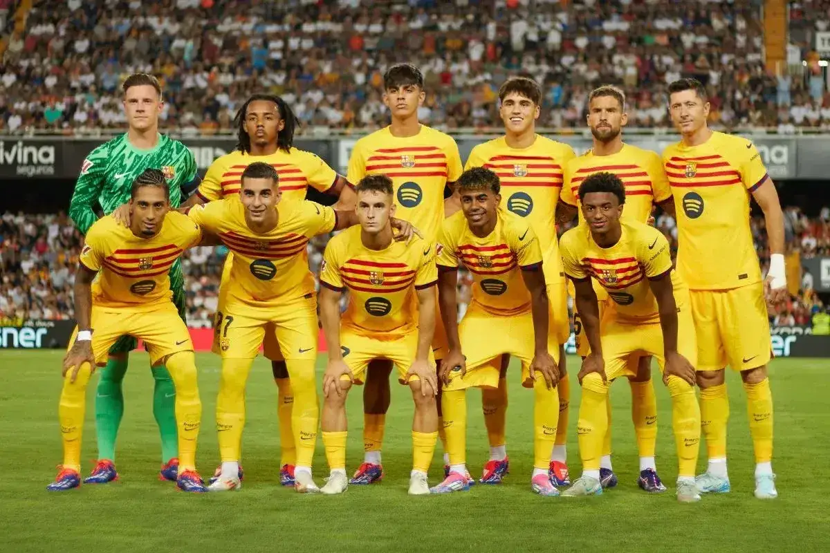 FC Barcelona – zawodnicy w żółtych strojach pozują do zdjęcia na boisku.