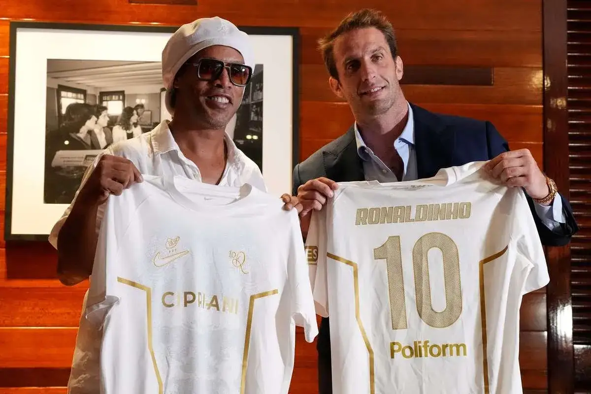 Ronaldinho prezentuje koszulkę z numerem 10, nawiązując do swojej kariery.