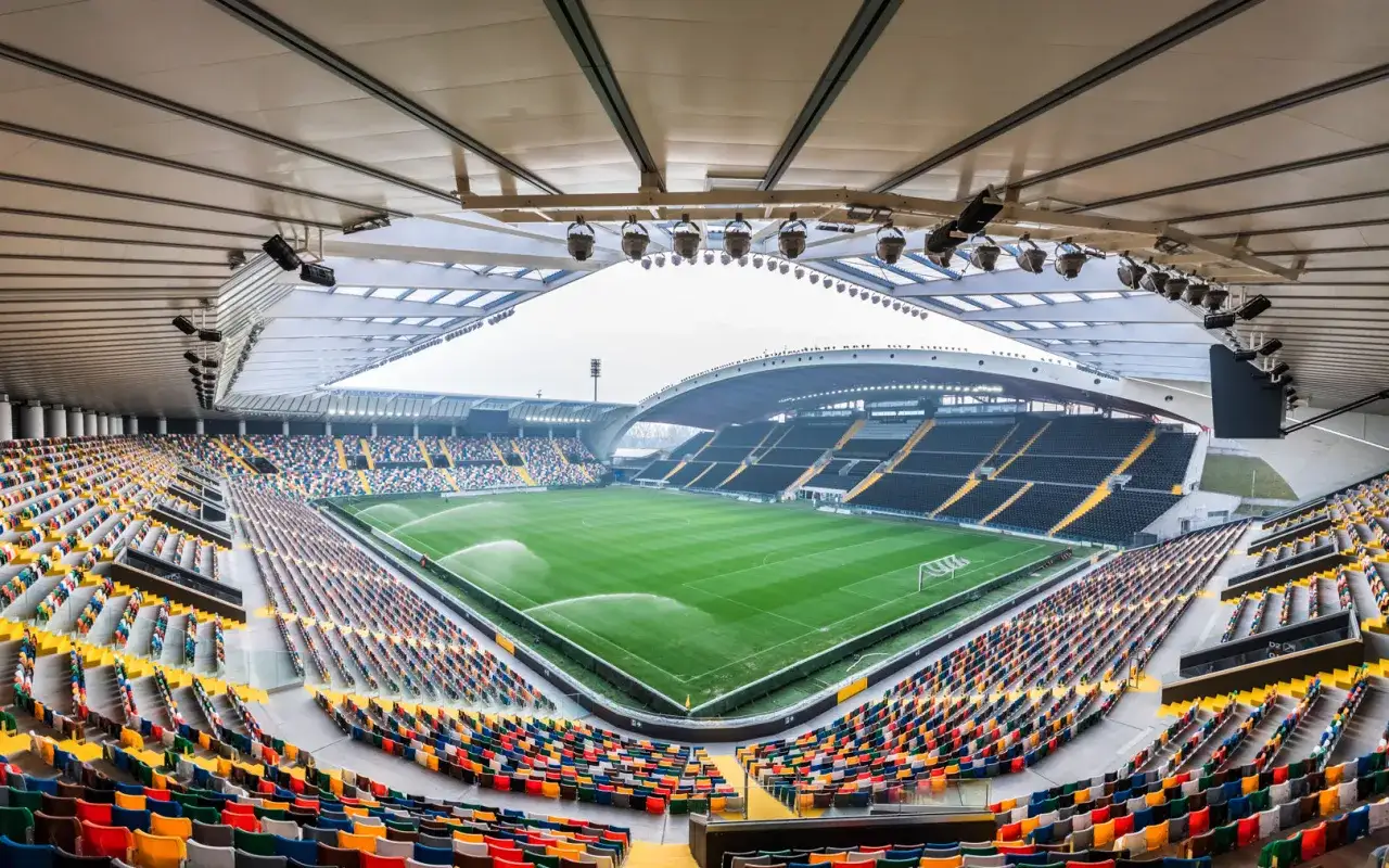Stadion gotowy na mecz Lecce – Udinese. Zielona murawa, kolorowe trybuny i nowoczesne oświetlenie czekają na kibiców.