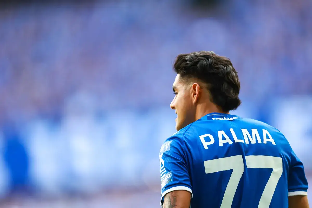 Luis Palma z Lecha Poznań w akcji. Piłkarz w niebieskiej koszulce z numerem 77.
