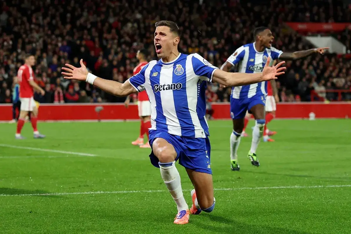 Piłkarz FC Porto w niebiesko-białej koszulce świętuje bramkę. Mimo że Jan Bednarek kontuzja nie dotyczy, radość na boisku jest widoczna.