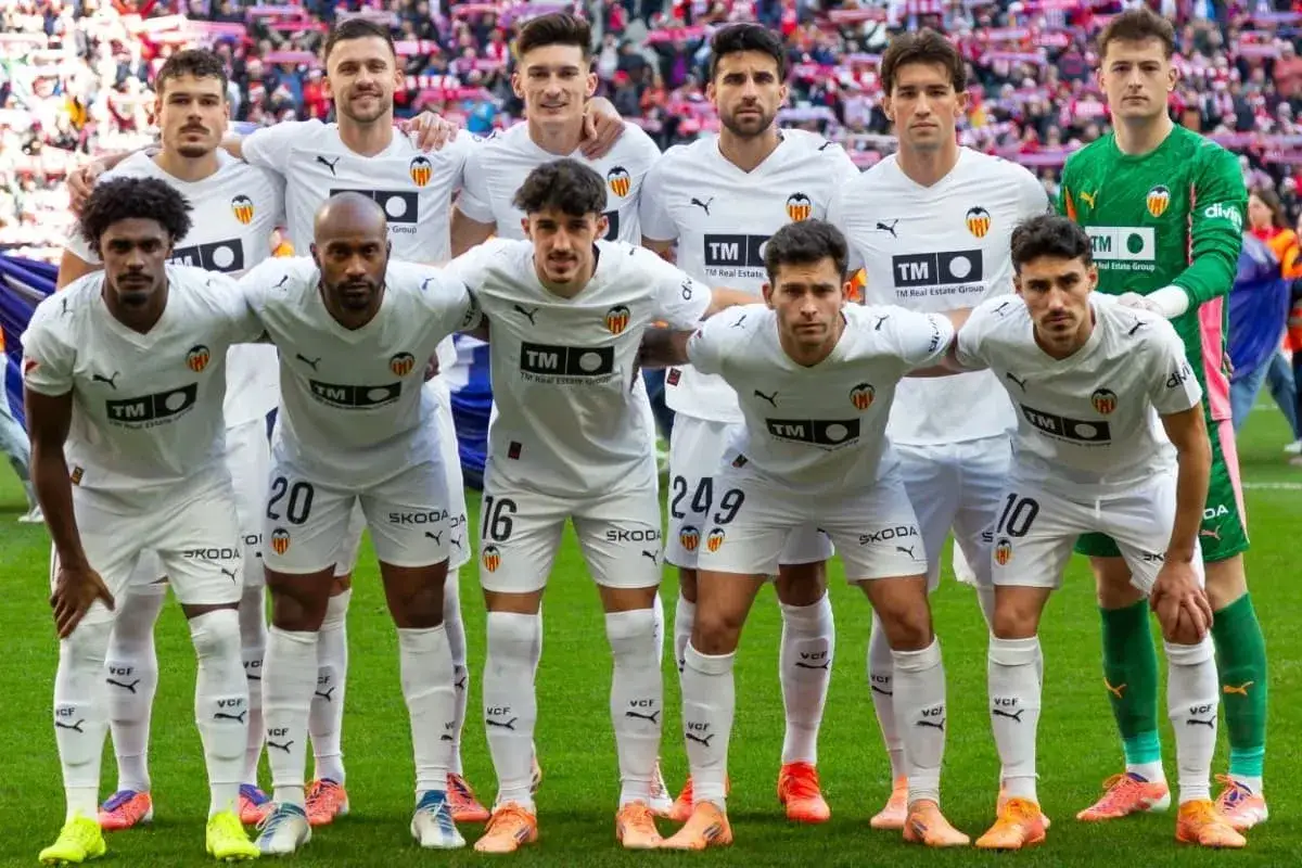 Valencia CF – zawodnicy w białych strojach pozują do zdjęcia na murawie. Widać numery na koszulkach: 20, 16, 249, 10.