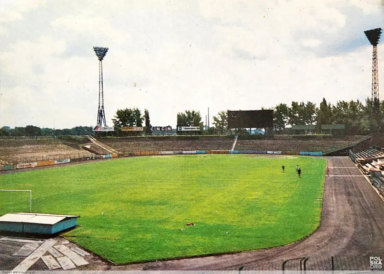 Widok na stary stadion ŁKS z zieloną murawą, trybunami i masztami oświetleniowymi.