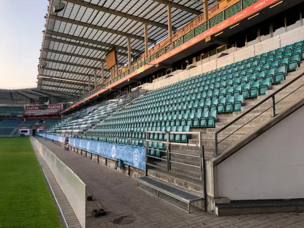 Puste trybuny stadionu A. Le Coq Arena czekają na kibiców. Zielone krzesełka tworzą morze nadziei na emocjonujące mecze.